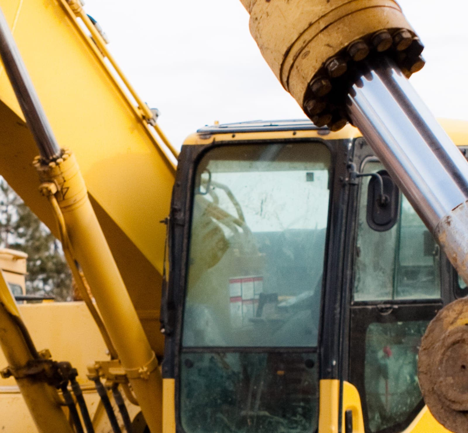 The cab and boom of a yellow excavator